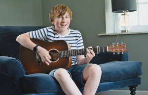 Child playing acoustic guitar